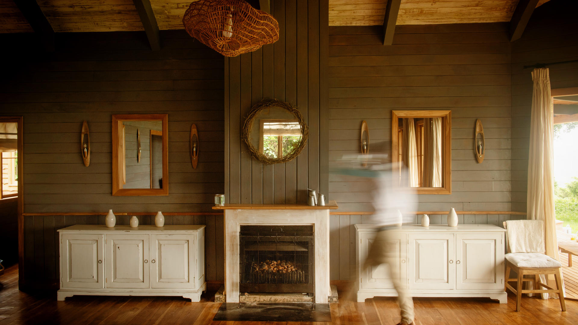 A waiter walks past the warming fire in the dining area