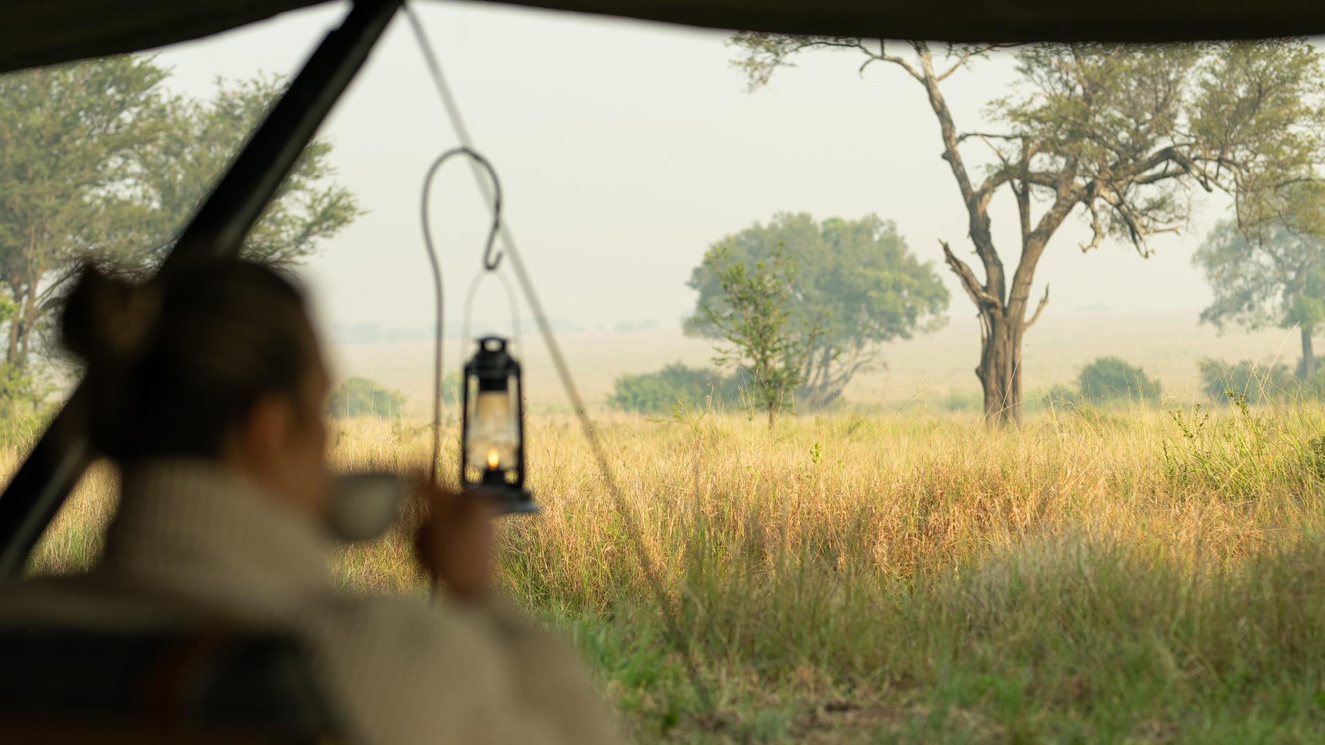 Asilia africa ubuntu migration camp guest enjoying a morning coffee while enjoying the view