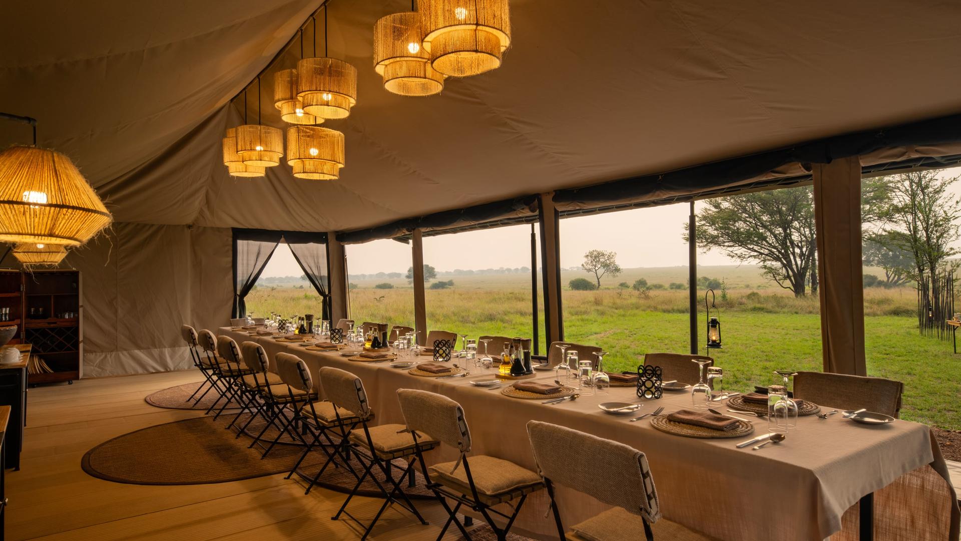 Asilia africa ubuntu migration camp dining setup in the main area