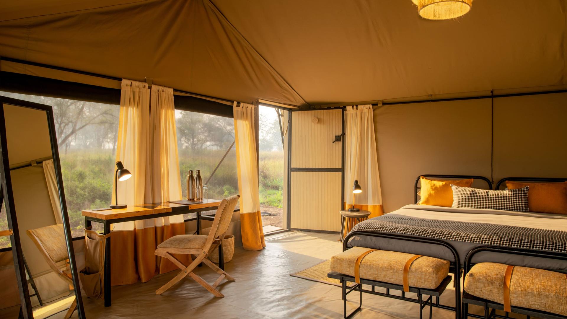 Asilia africa ubuntu migration camp guest tent interior with morning sun shining in
