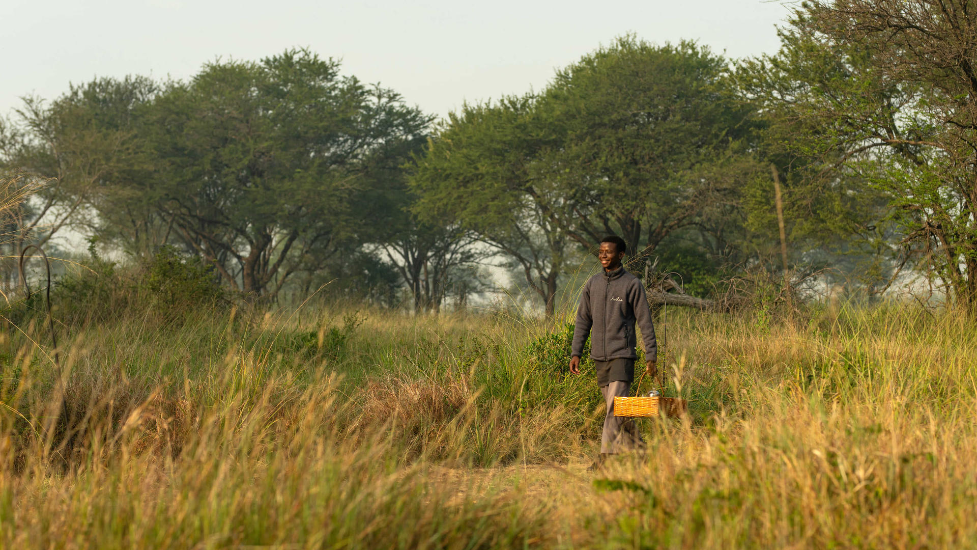 Asilia africa ubuntu migration camp staff member carrying basket
