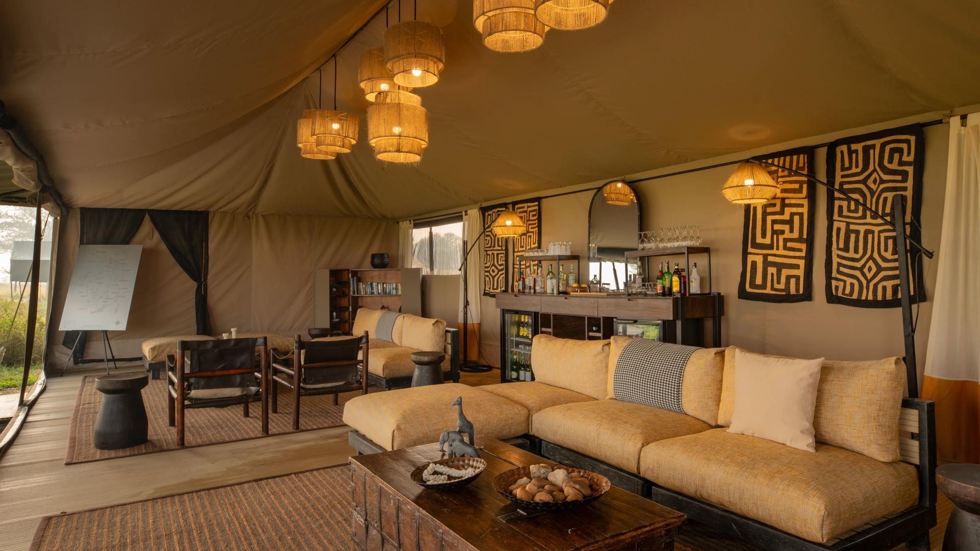 Asilia africa ubuntu migration camp lounge with couches in main area