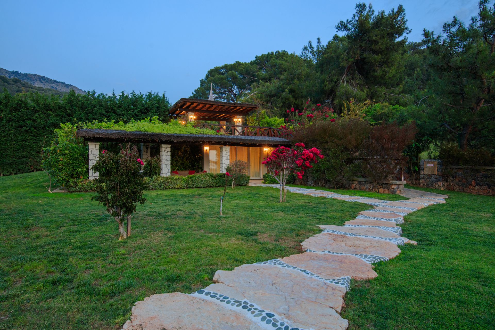 Villa gokce stone facade garden path evening