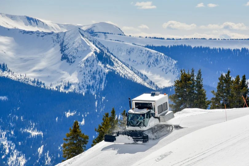 snow cat skiiing mountain top